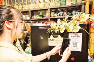 Покупатель оплачивает покупку с помощью QR-кода в одном из магазинов на улице Ванмиеу в Ханое.