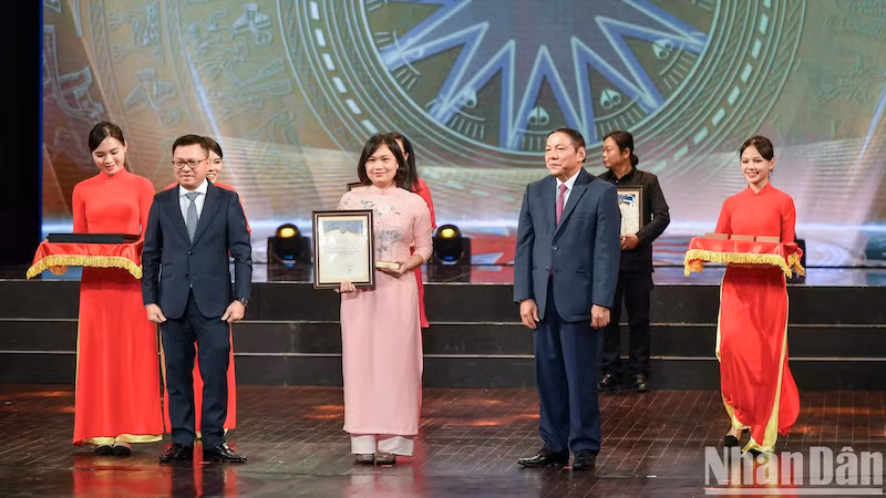 Главный редактор газеты «Нянзан», Замглавы Отдела ЦК КПВ по пропаганде и политическому воспитанию, Председатель Союза журналистов Вьетнама Ле Куок Минь, Министр культуры, спорта и туризма Нгуен Ван Хунг и обладатели вторых призов. Фото: Тхань Дат