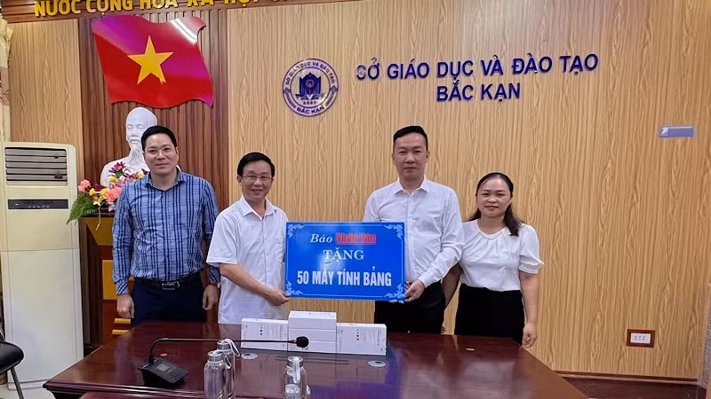 Начальник Канцелярии газеты «Нянзан» Ву Хоанг Винь вручает планшеты Департаменту образования и подготовки кадров провинции Баккан. Фото: Туан Шон