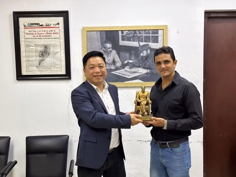 Заместитель главного редактора газеты «Нянзан» Кюэ Динь Нгуен вручает памятный подарок заместителю главного редактора газеты «Гранма».