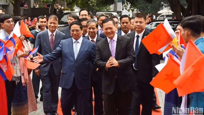 Студенты Университета внешней торговли встречают Премьер-министра Фам Минь Тьиня и Премьер-министра Камбоджи Хун Манета. Фото: Чан Хай