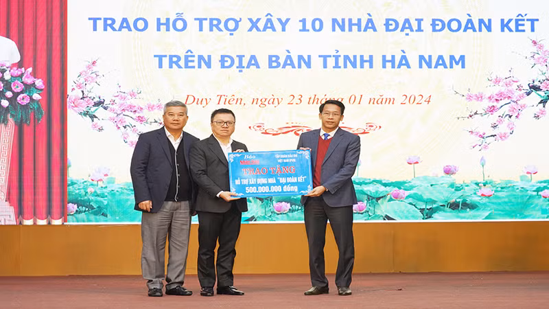 Руководители газеты «Нянзан» и Вьетнамской государственной нефтегазовой компании символически передают денежные средства для строительства домов великого единства представителю провинции Ханам.