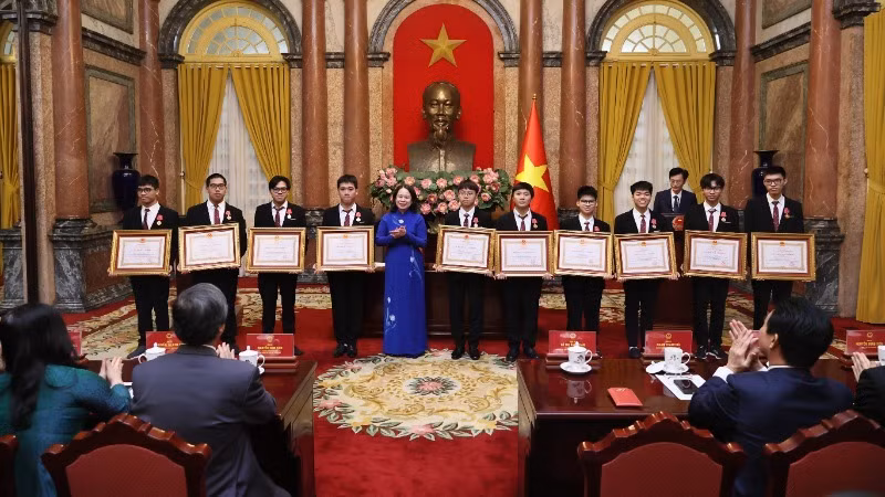 Вице-президент Во Тхи Ань Суан вручает школьникам ордена труда.