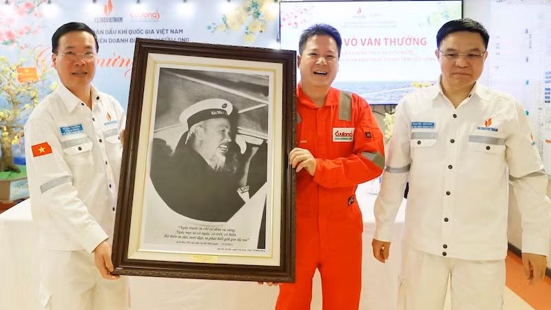 Президент Во Ван Тхыонг дарит фото Президента Хо Ши Мина сотрудникам предприятия Кыулонг. Фото: ВИА