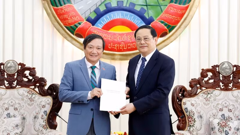 Посол Вьетнама в Лаосе Нгуен Ба Хунг (слева) вручает Премьер-министру Лаоса Сонексай Сипхандону поздравительную телеграмму от Генерального секретаря ЦК КПВ Нгуен Фу Чонга товарищу Кхамтай Сипхандону. Фото: ВИА