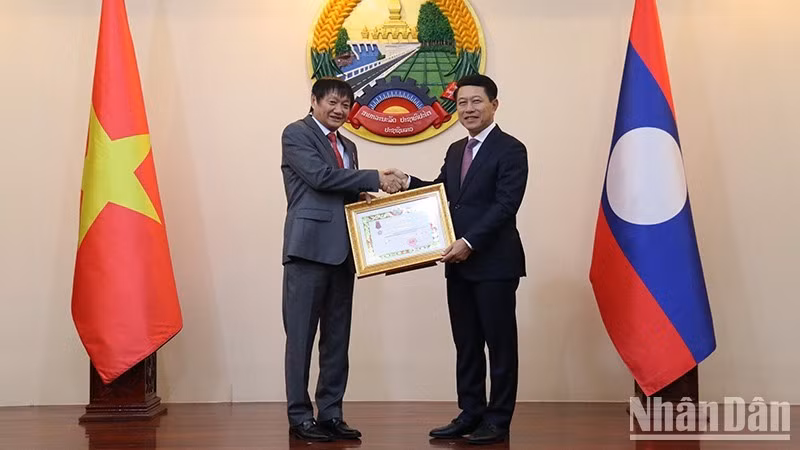 Вице-премьер, Министр иностранных дел Лаоса Салэмсай Коммасит вручает Орден Свободы 3-й степени Послу Вьетнама в Лаосе Нгуен Ба Хунгу. Фото: Хай Тиен