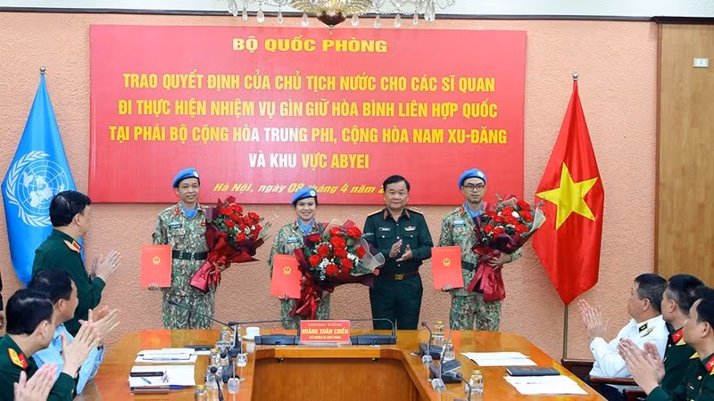 Генерал-полковник Хоанг Суан Тьиен вручает решения 3 офицерам.