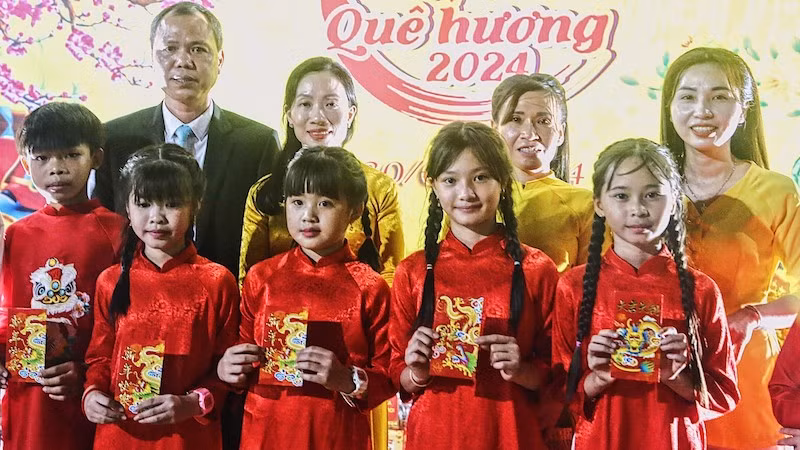 Генеральный консул Вьетнама в провинции Баттамбанг Нгуен Тхань Ван дарит ученикам счастливые деньги. Фото: ВИА