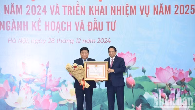 Премьер-министр Фам Минь Тьинь вручает ордена труда 1-й степени Министру планирования и инвестиций Нгуен Тьи Зунгу. Фото: Чан Хай