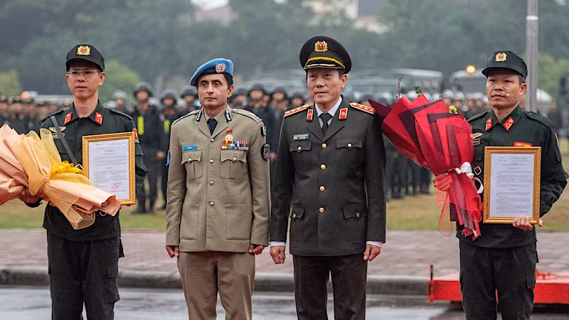 Замминистра общественной безопасности Лыонг Там Куанг, Комиссар полиции ООН Фейсал Шахкар и члены полицейского подразделения по поддержанию мира №1.