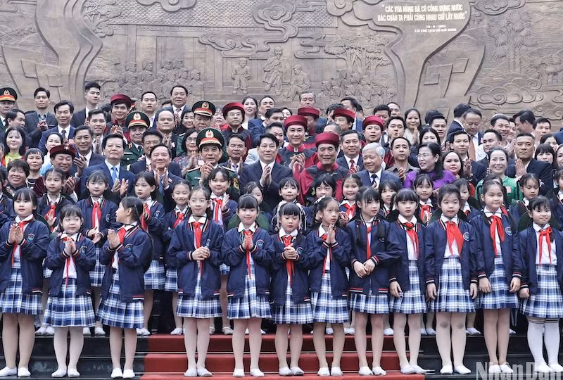 Президент Лыонг Кыонг, делегаты, местные жители и дети у барельефа, посвященного беседе между Дядюшкой Хо и кадровыми работниками, военнослужащими бригады авангарда. Фото: Нгок Лонг