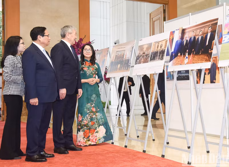 Оба Премьер-министра рассматривают фотографии, посвященные сотрудничеству между двумя странами. Фото: Чан Хай
