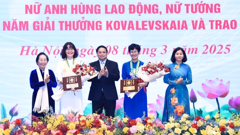 Премьер-министр Фам Минь Тьинь (в центре) поздравляет двух лауреатов премии имени С.В. Ковалевской 2024 года. Фото: Чан Хай 