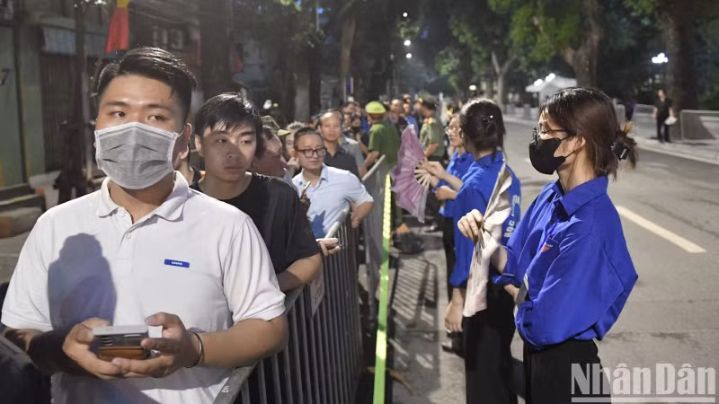Волонтеры готовы помочь людям, стоящим в очереди, чтобы почтить память Генерального секретаря ЦК КПВ Нгуен Фу Чонга.