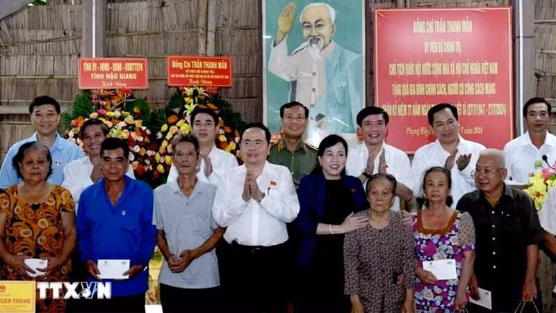 Председатель НС Чан Тхань Ман вручает подарки людям, имеющим заслуги перед революцией, и семьям льготной категории. Фото: ВИА