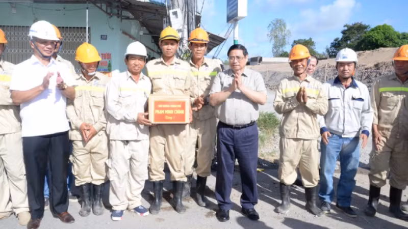 Премьер-министр Вьетнама Фам Минь Тьинь вручает подарки должностным лицам и рабочим.