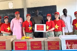 Представитель военно-инженерного подразделения № 4 вручает подарки учащимся средней школы Абьея. Фото: qdnd.vn