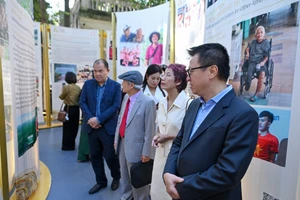 Главный редактор газеты «Нянзан» Ле Куок Минь и делегаты посещают выставку.