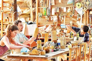 Туристы изготавливают сувениры из бамбука в ремесленной мастерской в Дананге. Фото: Ми Ха