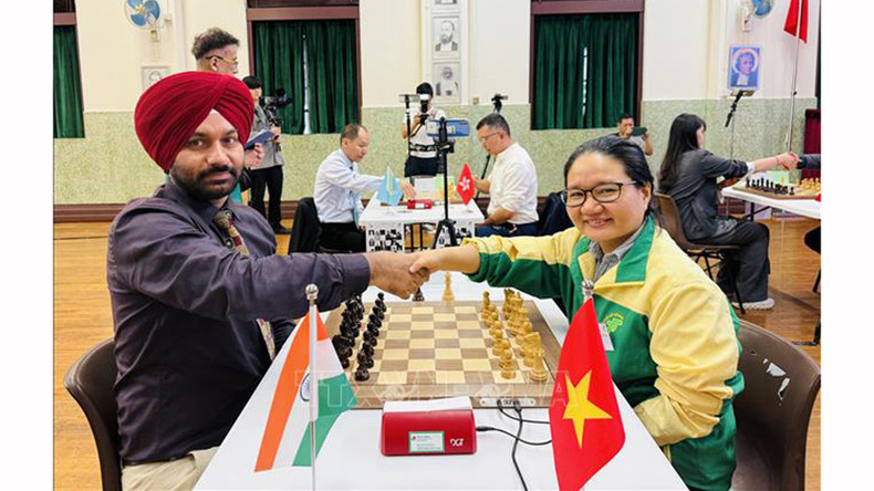 Шахматистка Хоанг Тхи Бао Чам пожимает руку индийскому игроку перед матчем. Фото: ВИА