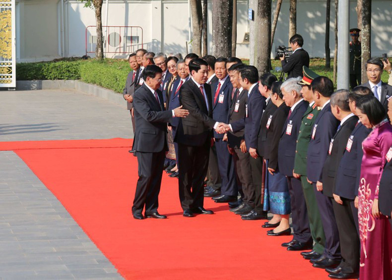 Президент Вьетнама Лыонг Кыонг пожимает руки лаосским делегатам.