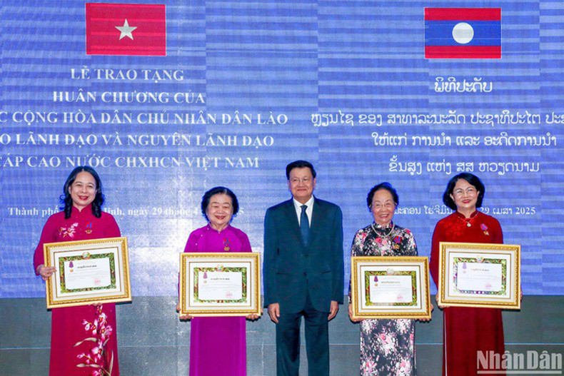 Генеральный секретарь ЦК НРПЛ, Президент Лаоса Тхонглун Сисулит вручает Ордена Свободы первой степени вьетнамским руководителям.