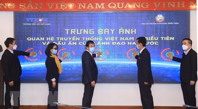 Делегаты нажимают кнопки в знак открытия фотовыставки. Фото: VNA