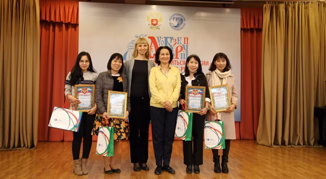 Представитель РУДН вручает грамоты университета вьетнамским русистам. Фото: Хоа Нгуен