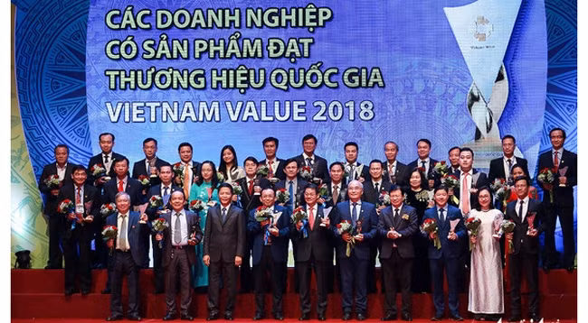 Представители предприятий, которым предоставляется право использовать на своей продукции национальный бренд 2018 года. Фото: tuoitre.vn