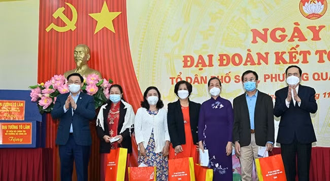 Товарищи Выонг Динь Хюэ и Чан Тхань Ман вручают подарки выдающимся семьям в жилом районе №6 квартала Куантхань района Бадинь города Ханоя. Фото: Зюи Линь