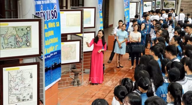 Ученики спецшколы имени Ле Хонг Фона провинции Намдинь изучают материалы, представленные на выставке. Фото: VNA