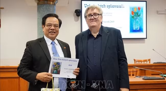 Нгуен Кует Тиен, один из двух главных авторов сборника, получает премию. Фото: VNA