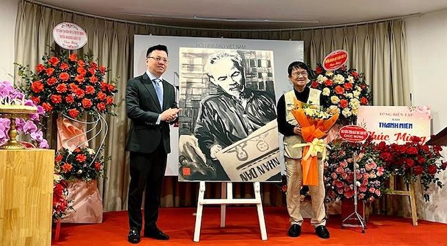Товарищ Ле Куок Минь от имени СЖВ получает картину «Дядя Хо читает газету «Нянзан»» – подарок журналиста Хюинь Зунг Няна.