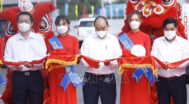 Президент Нгуен Суан Фук и делегаты разрезают ленту в знак открытия движения по главной дороге скоростной автомагистрали Чунглыонг – Митхуан. Фото: VNA