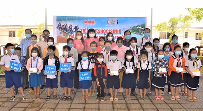 Представители газеты «Нянзан» в г. Кантхо и Бизнес-ассоциации провинции Камау вручают стипендии ученикам. Фото: Хыу Тунг