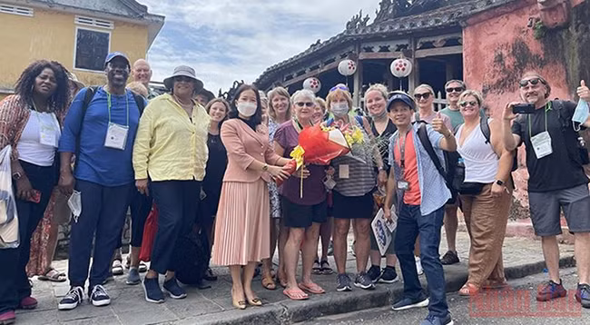 Представитель руководства города Хойан встречает первых американских туристов.