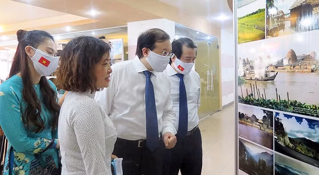 Замминистра культуры, спорта и туризма Та Куанг Донг и Замначальника Главного управления туризма Вьетнама Ха Ван Шиеу посещают выставку. Фото: Главное управление туризма Вьетнама
