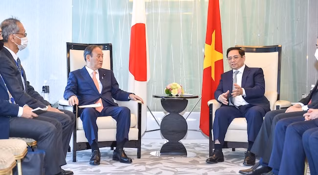 Премьер-министр Фам Минь Тьинь (справа) принимает бывшего Премьер-министра Японии Сугу Ёсихидэ. Фото: VGP