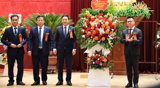 Товарищ Ле Куок Минь вручает цветы представителям газеты «Хоабинь».