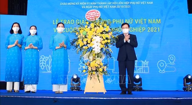Вице-премьер Фам Бинь Минь дарит поздравительные цветы Союзу женщин Вьетнама. Фото: VNA