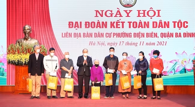 Президент Нгуен Суан Фук вручает подарки представителям семей, находящихся в трудной жизненной ситуации. Фото: VNA