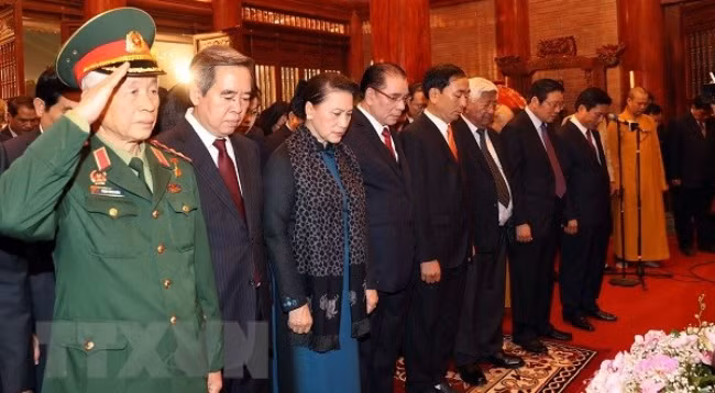 Председатель НС Нгуен Тхи Ким Нган и присутствующие чтят память погибших фронтовиков. Фото: VNA