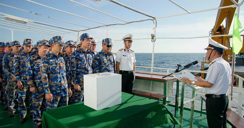 Полковник Ле Хонг Куанг, заместитель начальника политического отдела 2-го военно-морского округа, глава избирательного участка № 5, разъясняет избирателям правила голосования.