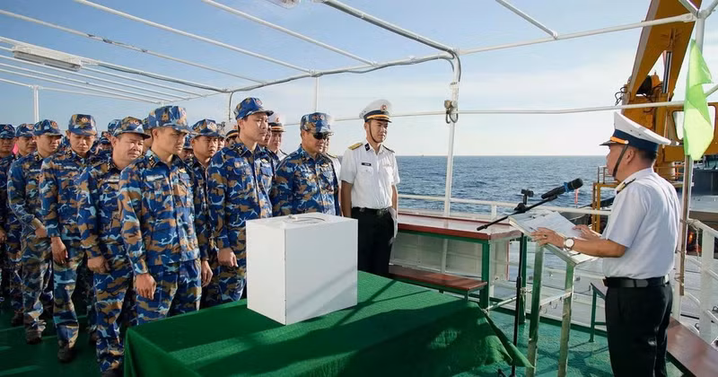 Полковник Ле Хонг Куанг, заместитель начальника политического отдела 2-го военно-морского округа, глава избирательного участка № 5, разъясняет избирателям правила голосования.