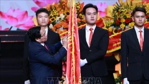 Премьер-министр Фам Минь Тьинь прикрепляет орден имени Хо Ши Мина к Знамени традиций Радио «Голос Вьетнама». Фото: ВИА