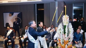 Генеральный секретарь ЦК КПВ То Лам (справа) и Генеральный секретарь ЦК НРПЛ, Президент Лаоса Тхонглун Сисулит принимают участие в традиционной лаосской церемонии завязывания нитей на запястьях, 5 февраля. (Фото: ВИА)