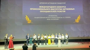 Лыу Тхи Нам Ха в желтом традиционном вьетнамском платье «аозай» в центре.
