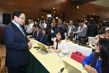 Премьер-министр Фам Минь Тьинь посещает пресс-центр XIV съезда КПВ. Фото: Зюи Линь