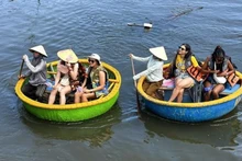 Иностранные туристы пробуют катание на лодке-корзине в кокосовом лесу Камтхань. Фото: ВИА