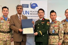 Представитель ООН вручает Департаменту миротворческих операций Вьетнама сертификат, подтверждающий, что курс для штабных офицеров ООН соответствует стандартам предмиссионной подготовки ООН.